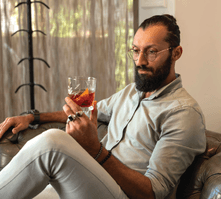 Marshall, Kove Collection's Group Mixologist, admiring his Negroni while sitting on the couch
